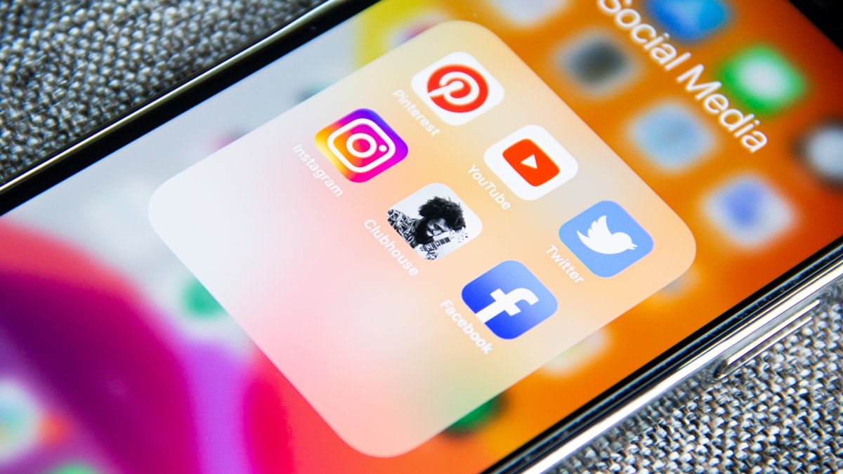 Phone showing an Instagram profile next to a laptop